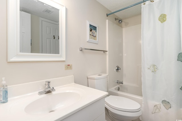 full bathroom featuring tile patterned floors, toilet, shower / bath combo with shower curtain, vanity, and a textured ceiling