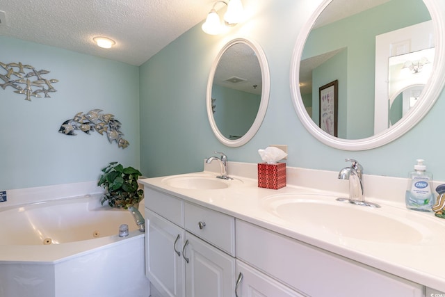 bathroom with vanity, a textured ceiling, and a tub to relax in