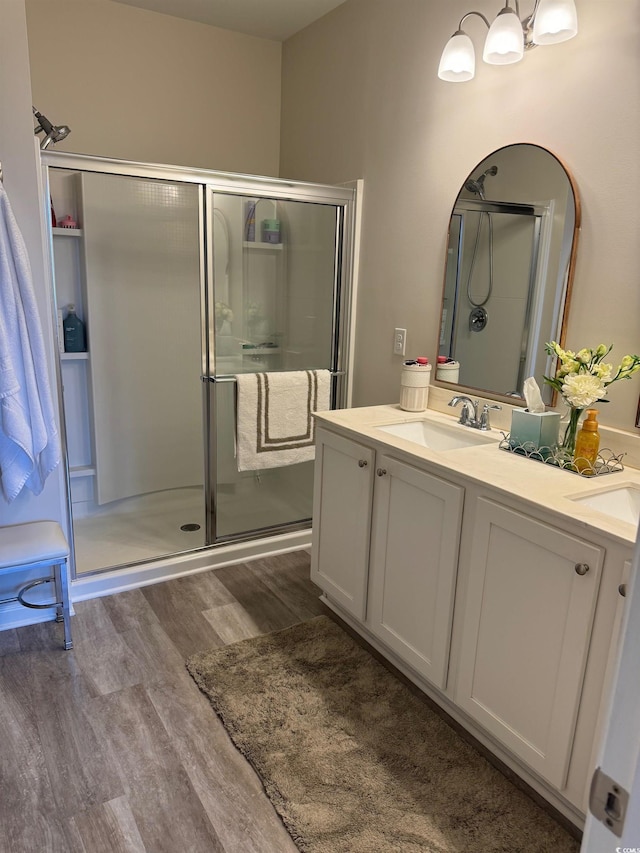 bathroom with vanity, a shower with shower door, and wood-type flooring