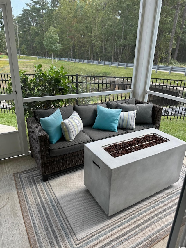 wooden terrace with a lawn and an outdoor living space with a fire pit