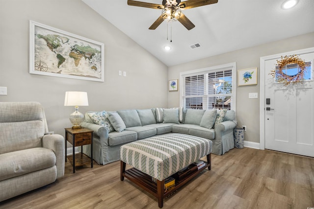 living room with ceiling fan, light hardwood / wood-style floors, and lofted ceiling