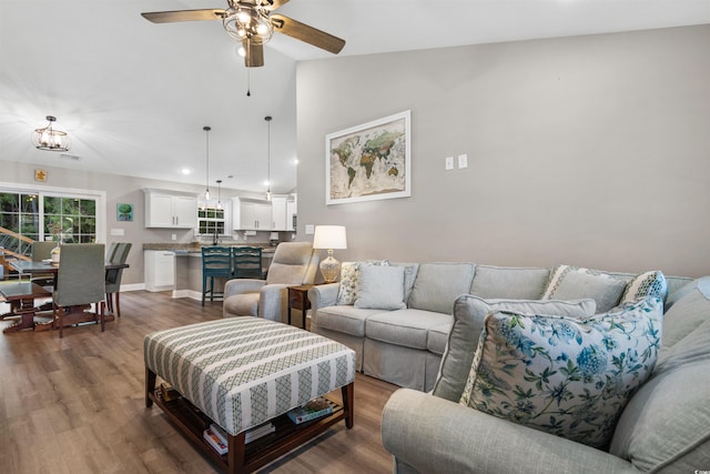 living room featuring dark hardwood / wood-style floors, ceiling fan, and lofted ceiling