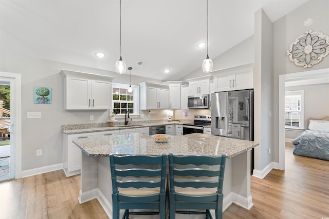 kitchen featuring a breakfast bar area, a center island, white cabinets, and stainless steel appliances