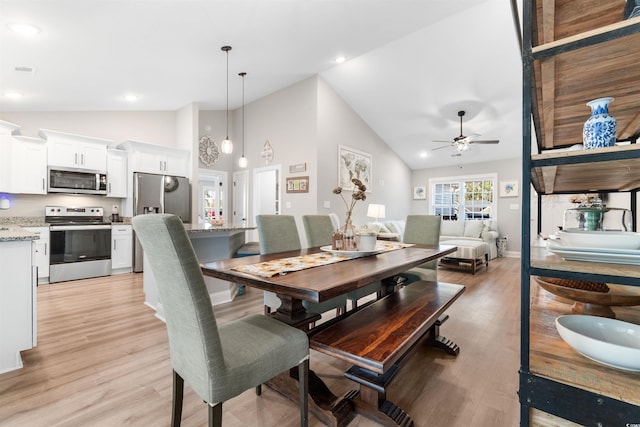 dining area featuring light hardwood / wood-style floors, high vaulted ceiling, and ceiling fan