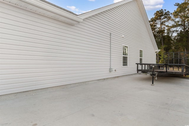 view of property exterior with a patio and a deck