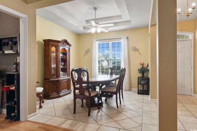 490 Blackberry Ln, Myrtle Beach, SC 29579 - dining room featuring light tile patterned flooring, a raised ceiling, baseboards, and ceiling fan with notable chandelier