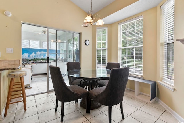 dining area with light tile patterned floors, ceiling fan with notable chandelier, and a wealth of natural light