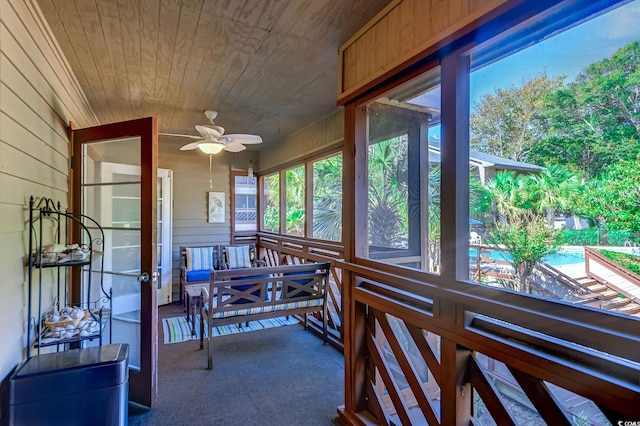 sunroom featuring wood ceiling and ceiling fan