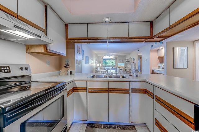 kitchen with stainless steel electric stove, white cabinets, kitchen peninsula, a notable chandelier, and sink