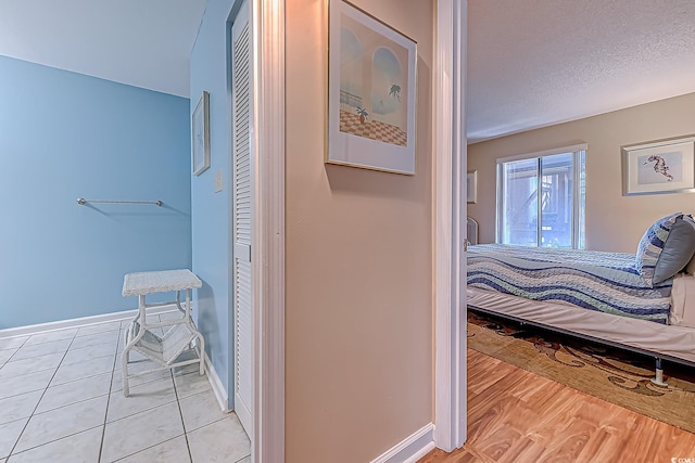 bedroom featuring a textured ceiling and light hardwood / wood-style flooring