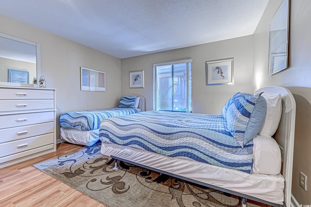 bedroom with hardwood / wood-style floors and a textured ceiling