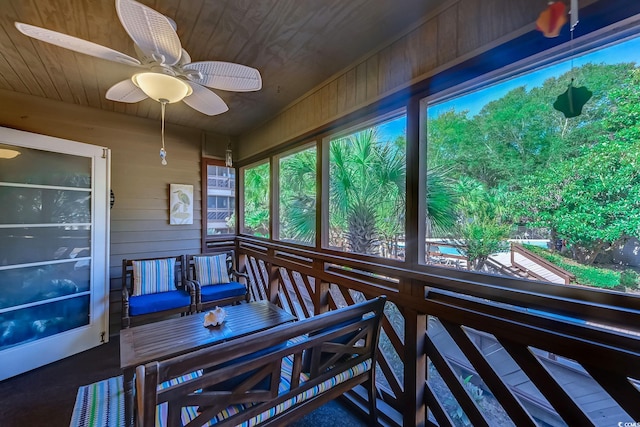 sunroom / solarium featuring ceiling fan and wooden ceiling