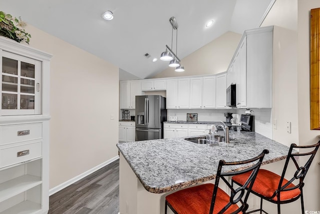 kitchen with appliances with stainless steel finishes, white cabinets, and kitchen peninsula