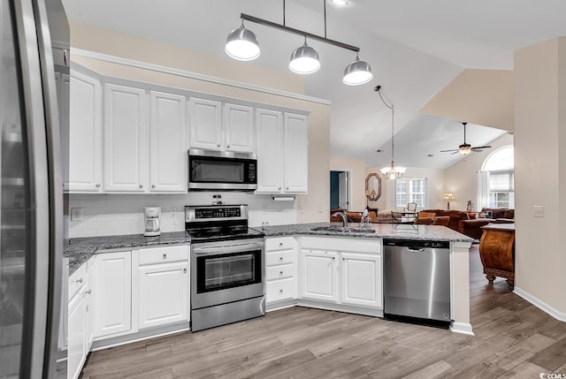 kitchen featuring appliances with stainless steel finishes, sink, white cabinets, hanging light fixtures, and kitchen peninsula