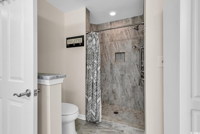 bathroom featuring toilet and walk in shower