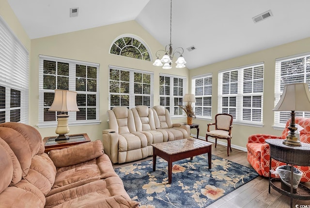 sunroom / solarium featuring an inviting chandelier and vaulted ceiling