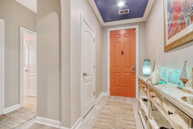 entryway with light hardwood / wood-style floors and ornamental molding