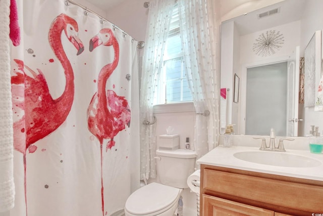 bathroom with a shower with shower curtain, vanity, and toilet