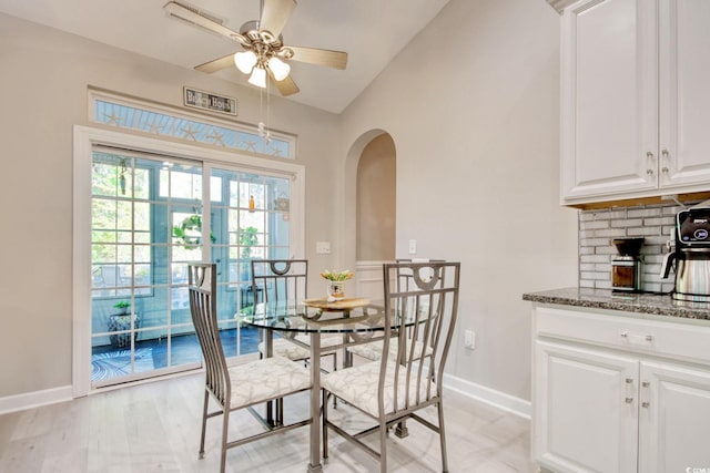 dining room featuring light hardwood / wood-style floors, vaulted ceiling, and ceiling fan