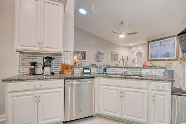 kitchen with white cabinets, tasteful backsplash, sink, dark stone countertops, and dishwasher