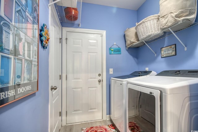 laundry room with washer and dryer and light wood-type flooring