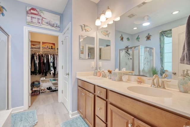 bathroom with hardwood / wood-style floors, vanity, and walk in shower