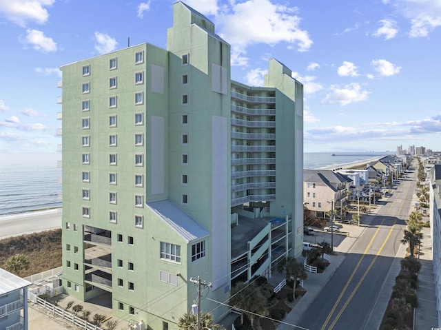 view of building exterior featuring a beach view and a water view