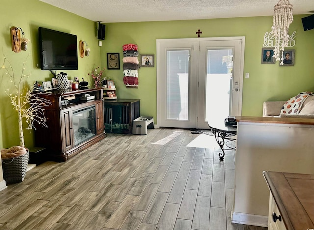 doorway to outside with light hardwood / wood-style floors and a textured ceiling