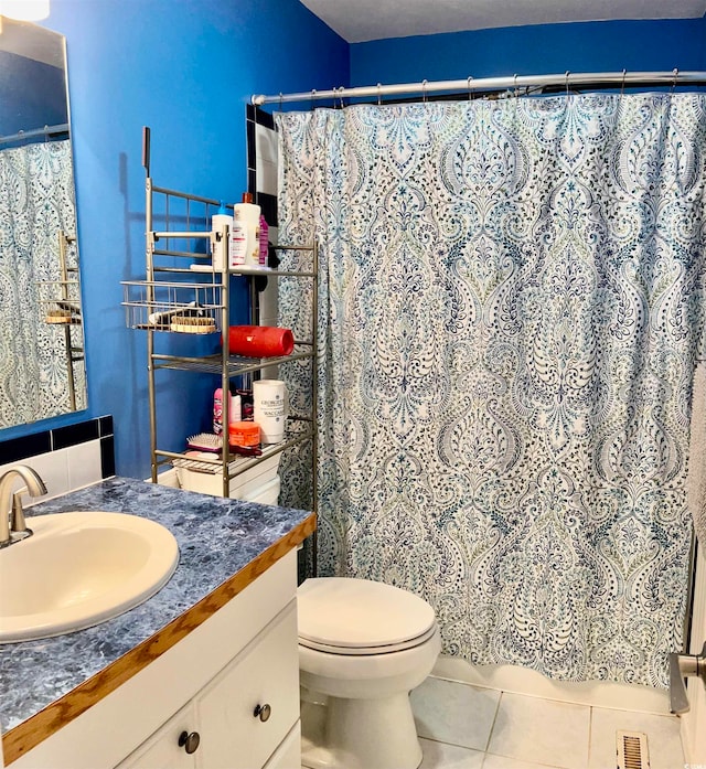 bathroom with vanity, a shower with curtain, toilet, and tile patterned floors