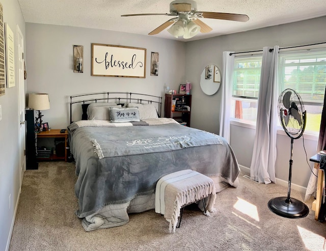 bedroom featuring ceiling fan, a textured ceiling, and carpet floors