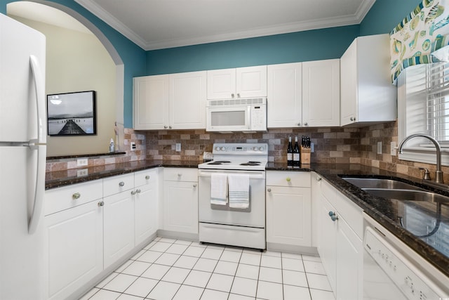 kitchen featuring decorative backsplash, dark stone countertops, sink, white cabinetry, and white appliances