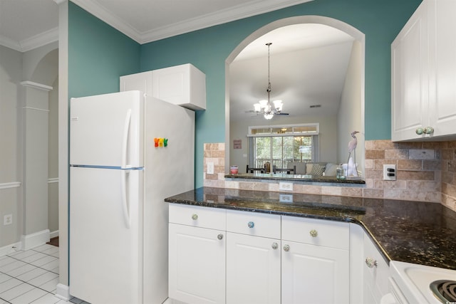5750 Oyster Catcher Dr Unit 1134, North Myrtle Beach, SC 29582 - kitchen with white cabinetry, decorative backsplash, freestanding refrigerator, arched walkways, and a notable chandelier