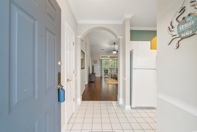 entryway featuring decorative columns, ceiling fan, ornamental molding, and light hardwood / wood-style flooring