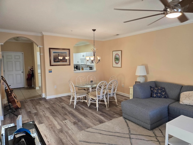 living room featuring ornamental molding, wood-type flooring, and ceiling fan