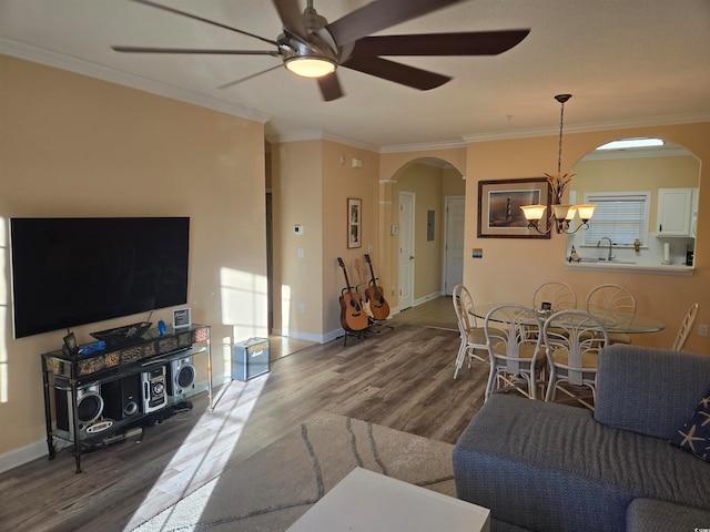 living room with crown molding, hardwood / wood-style flooring, sink, and ceiling fan with notable chandelier