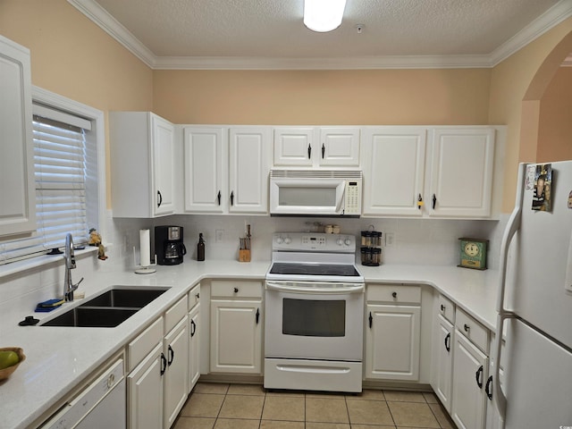 kitchen with ornamental molding, sink, white cabinets, and white appliances