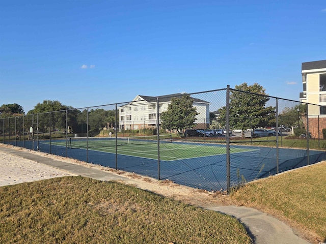 view of sport court featuring a lawn