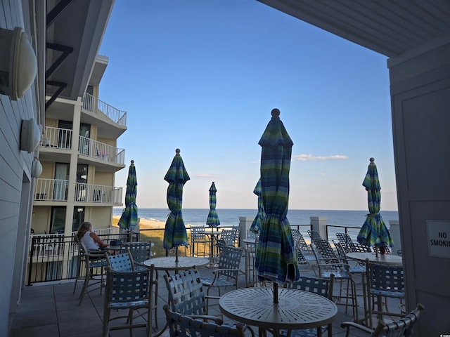 view of patio featuring a water view and a balcony