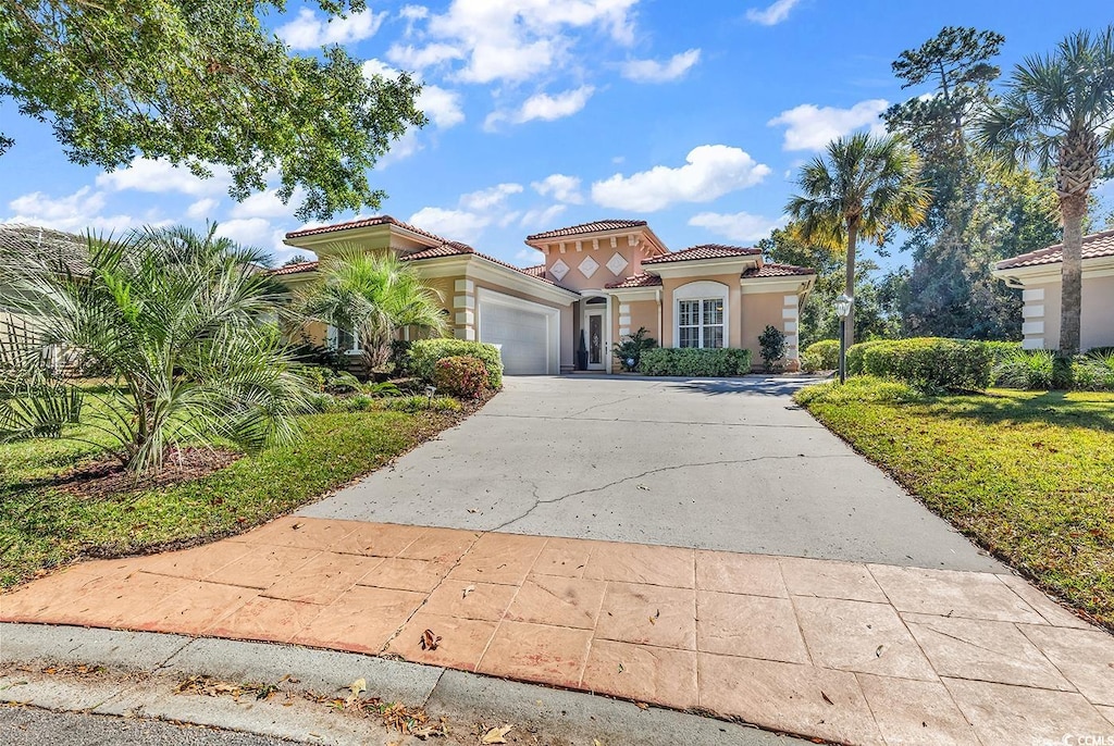 mediterranean / spanish-style house with a garage and a front yard