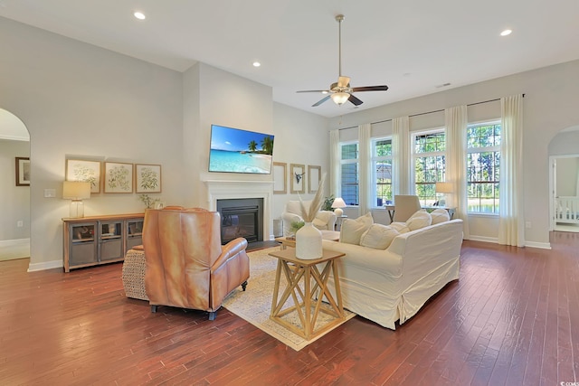 living room with dark wood-type flooring and ceiling fan