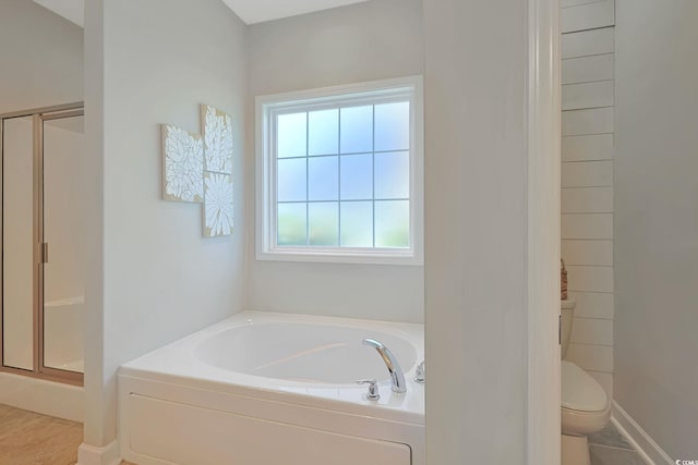 bathroom featuring toilet, shower with separate bathtub, and tile patterned floors