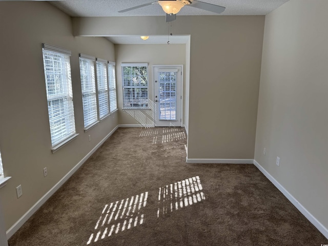 carpeted empty room with ceiling fan and a textured ceiling