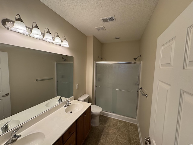 bathroom featuring a textured ceiling, toilet, an enclosed shower, and vanity