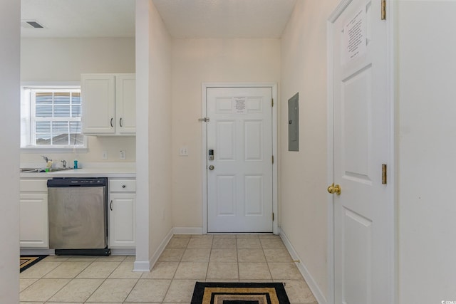 interior space featuring electric panel, light tile patterned floors, white cabinetry, a textured ceiling, and dishwasher