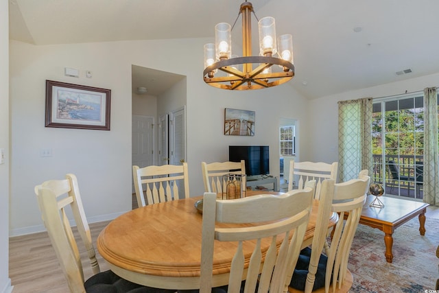 dining space featuring a notable chandelier, light hardwood / wood-style flooring, a healthy amount of sunlight, and lofted ceiling