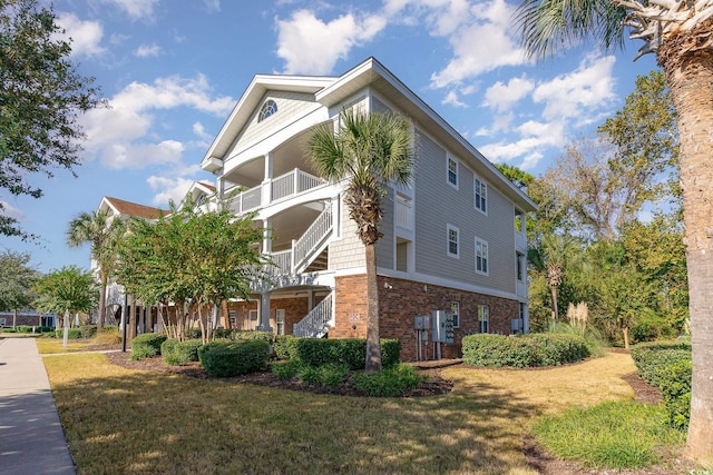 view of side of property featuring a yard and a balcony