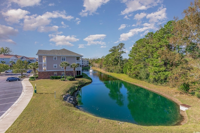 exterior space featuring a lawn and a water view