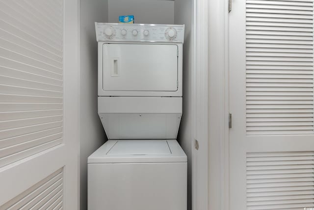 laundry room with stacked washing maching and dryer