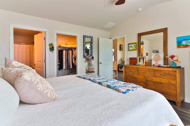 bedroom featuring lofted ceiling, a walk in closet, hardwood / wood-style flooring, connected bathroom, and a closet