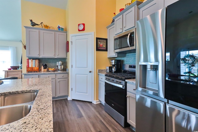 kitchen with backsplash, dark hardwood / wood-style floors, sink, gray cabinetry, and stainless steel appliances